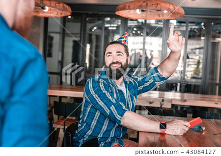 Dark-haired man feeling cheerful seeing his friends on birthday 43084127