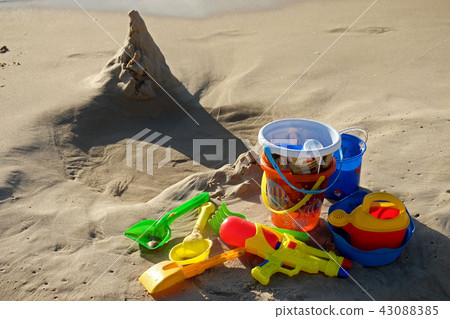 Children's toys and a sand tower on the beach 43088385