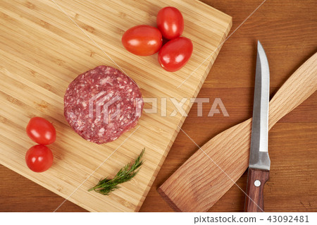Raw cutlet of minced meat on a wooden cutting board. 43092481