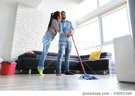 Man And Woman Kissing While Cleaning Home 43093166