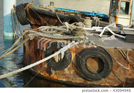 A rusted steel ship anchored at the port A rusted steel ship anchored at the port 43094948