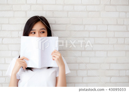 beautiful portrait asian woman hiding behind book 43095033