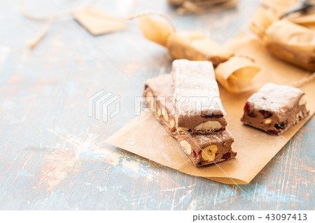 A variety of different nutty nougat in dark chocolate with roasted hazelnuts cut open to show the A variety of different nutty nougat in dark chocolate with roasted hazelnuts cut open to show the 43097413