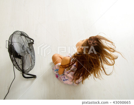 the girl is sitting in front of the fan the girl is sitting in front of the fan 43098665