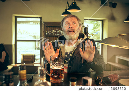 The senior bearded male drinking beer in pub The senior bearded male drinking beer in pub 43098830