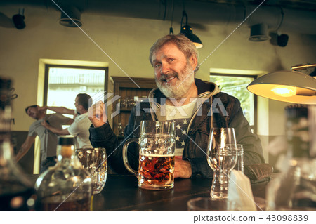 The senior bearded male drinking beer in pub 43098839
