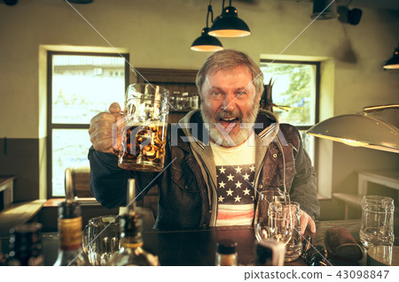 The senior bearded male drinking beer in pub 43098847