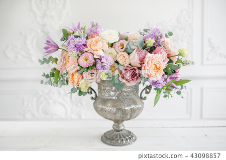 Gorgeous bouquet of different flowers. floral arrangement in vintage metal vase. table setting Gorgeous bouquet of different flowers. floral arrangement in vintage metal vase. table setting 43098857