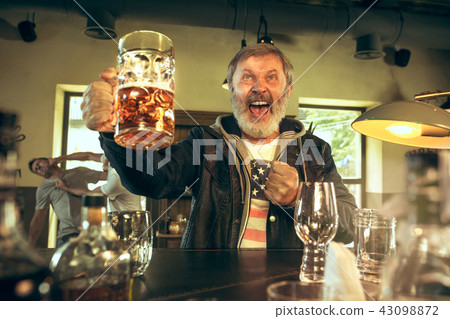 The senior bearded male drinking beer in pub 43098872