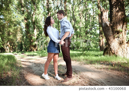 young couple walking in the forest, summer nature 43100068
