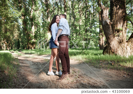 young couple walking in the forest, summer nature young couple walking in the forest, summer nature 43100069