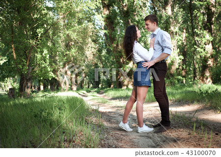 young couple walking in the forest, summer nature 43100070