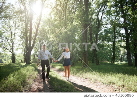 young couple walking in the forest, summer nature 43100090