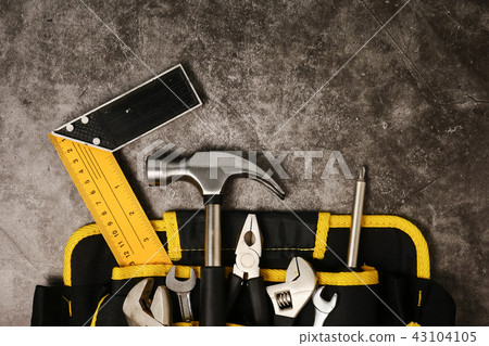 Construction worker belt with tools on concrete texture backgrou