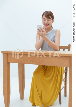 A young lady who is happy to see a smartphone A young lady who is happy to see a smartphone 43105292