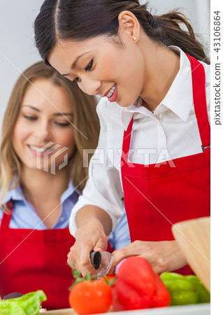Two Happy Women Cooking Preparing Food in Kitchen Two Happy Women Cooking Preparing Food in Kitchen 43106864