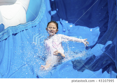 A girl playing with a water slider 43107995