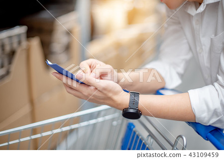 Asian man checking the shopping list in warehouse 43109459