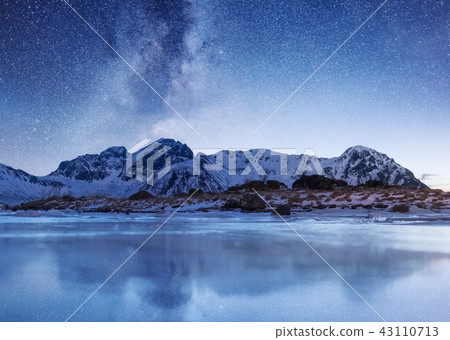 Night sky and reflection on the frozen lake. 43110713