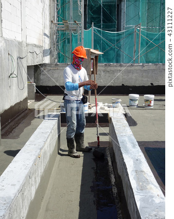 Waterproofing layer applied by construction worker Waterproofing layer applied by construction worker 43111227