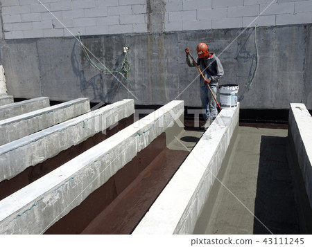 Waterproofing layer applied by construction worker Waterproofing layer applied by construction worker 43111245