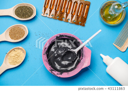 Photo from above with pink cup with black clay, mask oils, wooden spoons, combs, with spoon 43111863