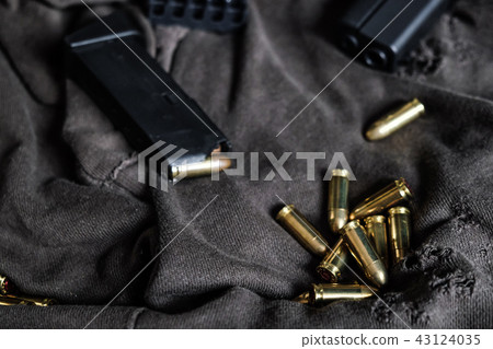 9mm autometic hand gun with FMJ bullet on fabric 9mm autometic hand gun with FMJ bullet on fabric 43124035