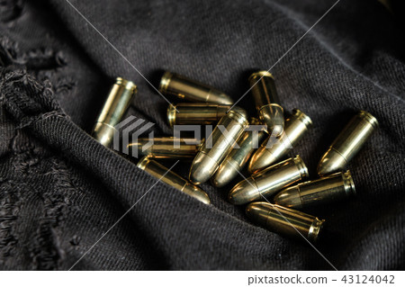 Full metal jacket 9mm bullet on cloth texture 43124042