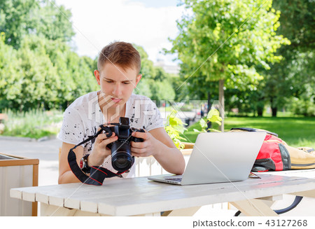 Attractive young man student using laptop outside Attractive young man student using laptop outside 43127268