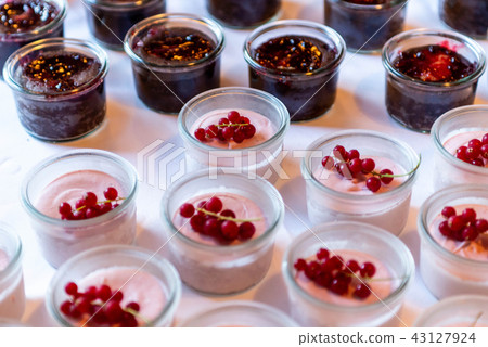 Closeup many dessert jar rowed up on buffet table with fresh fruits jelly and cream 43127924
