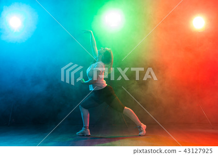 People, dancing and jazz funk concept - European young woman demonstrates flexibility over colored 43127925