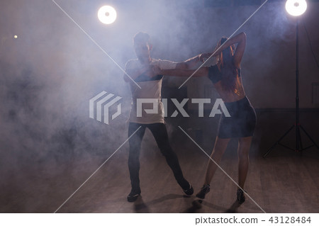 Young couple dancing latin dance Bachata, merengue, salsa. Two elegance pose in dance class Young couple dancing latin dance Bachata, merengue, salsa. Two elegance pose in dance class 43128484