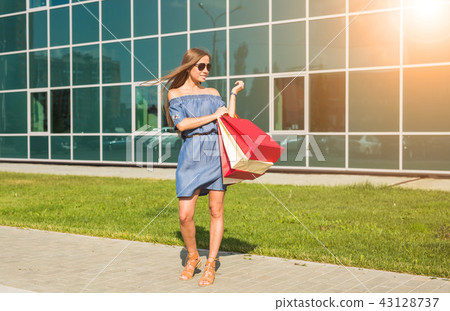 Purchase, sale and people concept - young happy smiling woman with shopping bags 43128737
