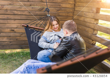 Love, pregnancy and family concept - Man hugging his pregnant wife Love, pregnancy and family concept - Man hugging his pregnant wife 43128854