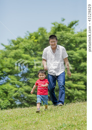 Father and son playing in a fresh green park 43129829