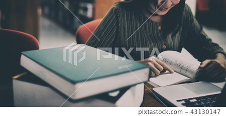 Young woman are reading a book in the library. 43130147