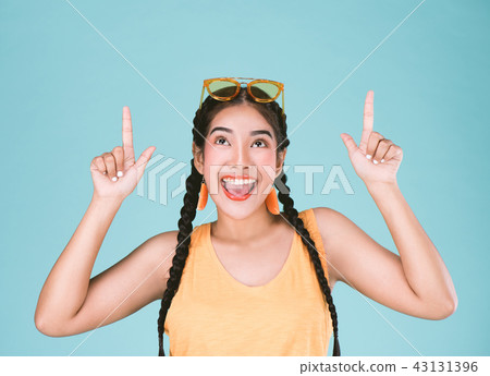 Portrait of a fitness woman pointing fingers up Portrait of a fitness woman pointing fingers up 43131396