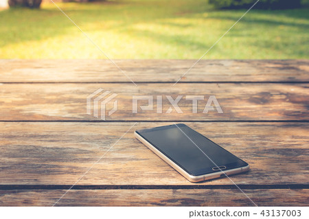Black smartphone place on wooden table. Black smartphone place on wooden table. 43137003