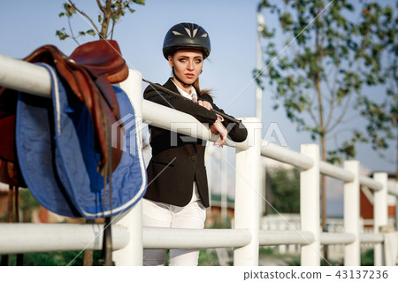elegant rider woman in helmet with whip 43137236