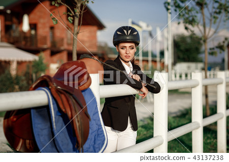 elegant rider woman in helmet with whip 43137238