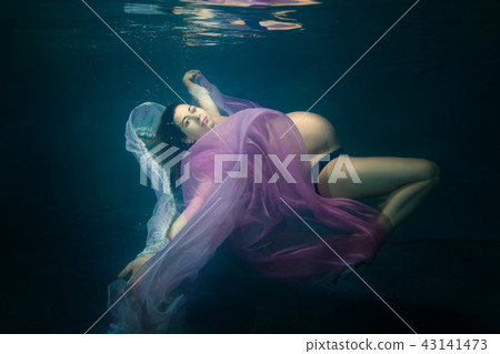 Pregnant woman under water. Pregnant woman under water. 43141473