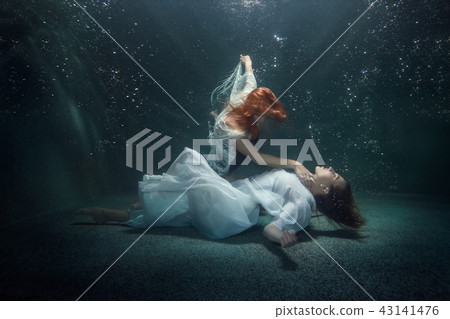 Two young women under the water. 43141476