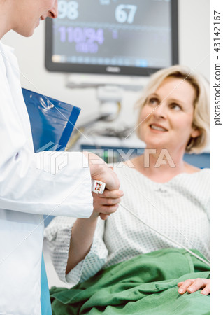 Doctor shaking hands of patient recovering after operation in hospital 43142167