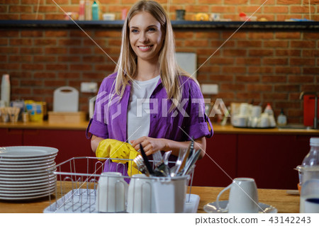 Young beautiful woman works in kitchen Young beautiful woman works in kitchen 43142243