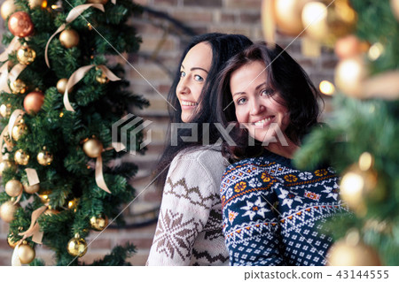 Portrait of young women posing near Christmas decorations on party 43144555