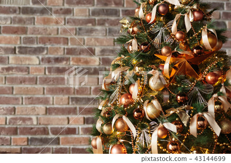 Decorated Christmas tree against brick wall 43144699
