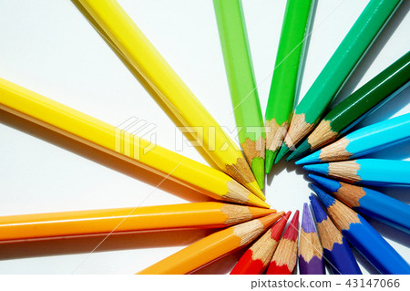 各種各樣的顏色色的鉛筆做一個圓的彩虹反對他們的頭。 43147066