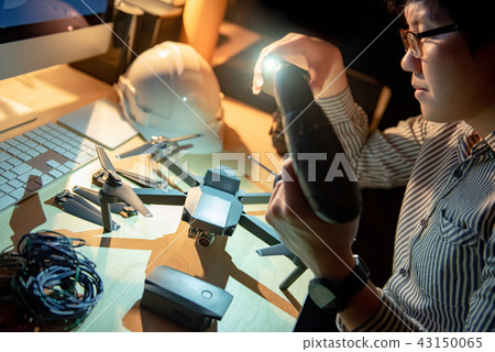 Technician using electric screwdriver with drone Technician using electric screwdriver with drone 43150065