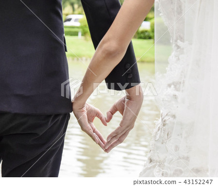 Back view of bride in white dress and groom heart 43152247
