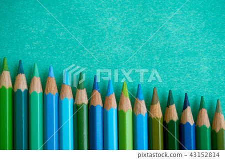 Blue colored pencils, such as blue, green, and blue, placed side by side on a green background. Blue colored pencils, such as blue, green, and blue, placed side by side on a green background. 43152814
